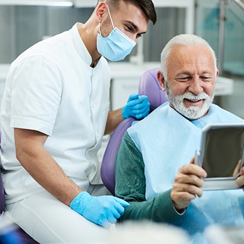 Patient looking at reflection in mirror with dentist